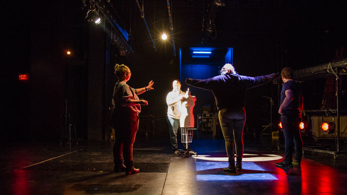 Cornell College students and their professor work on the lighting for a theatre production