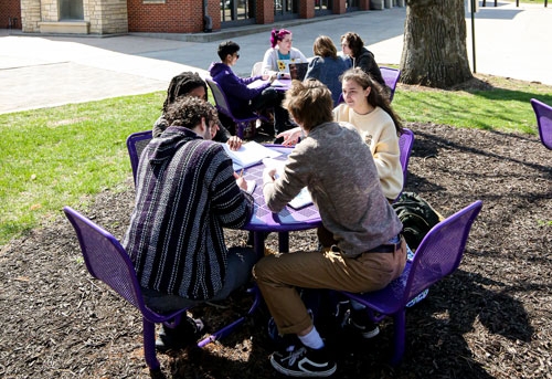Cornell students gathered at tables on the campus lawn
