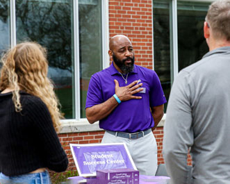 A student talks to an admission counselor about Cornell College at a college fair.
