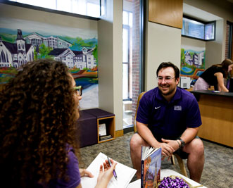 A student talks to an admission counselor about Cornell College at a college fair.