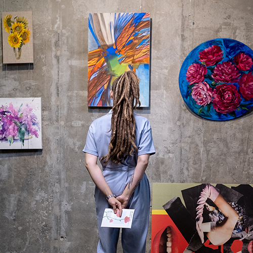 Student in an art gallery examining paintings