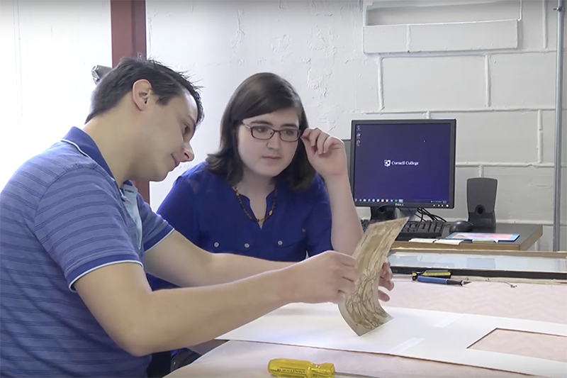 Students examining a historic art print