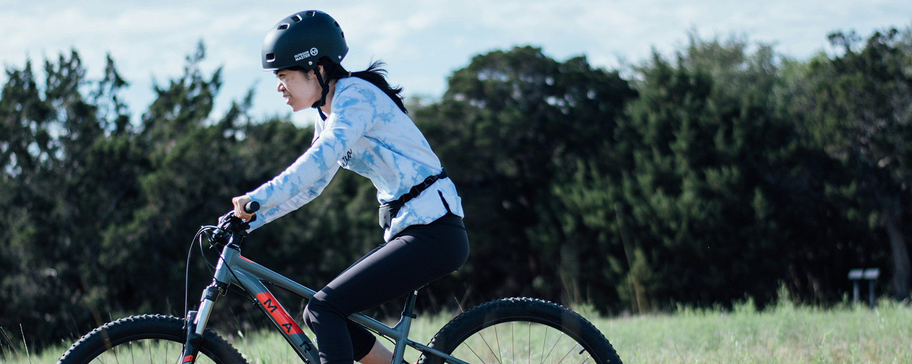 Young woman riding a bike outside and exploring - photo by Iris Want on Unsplash 