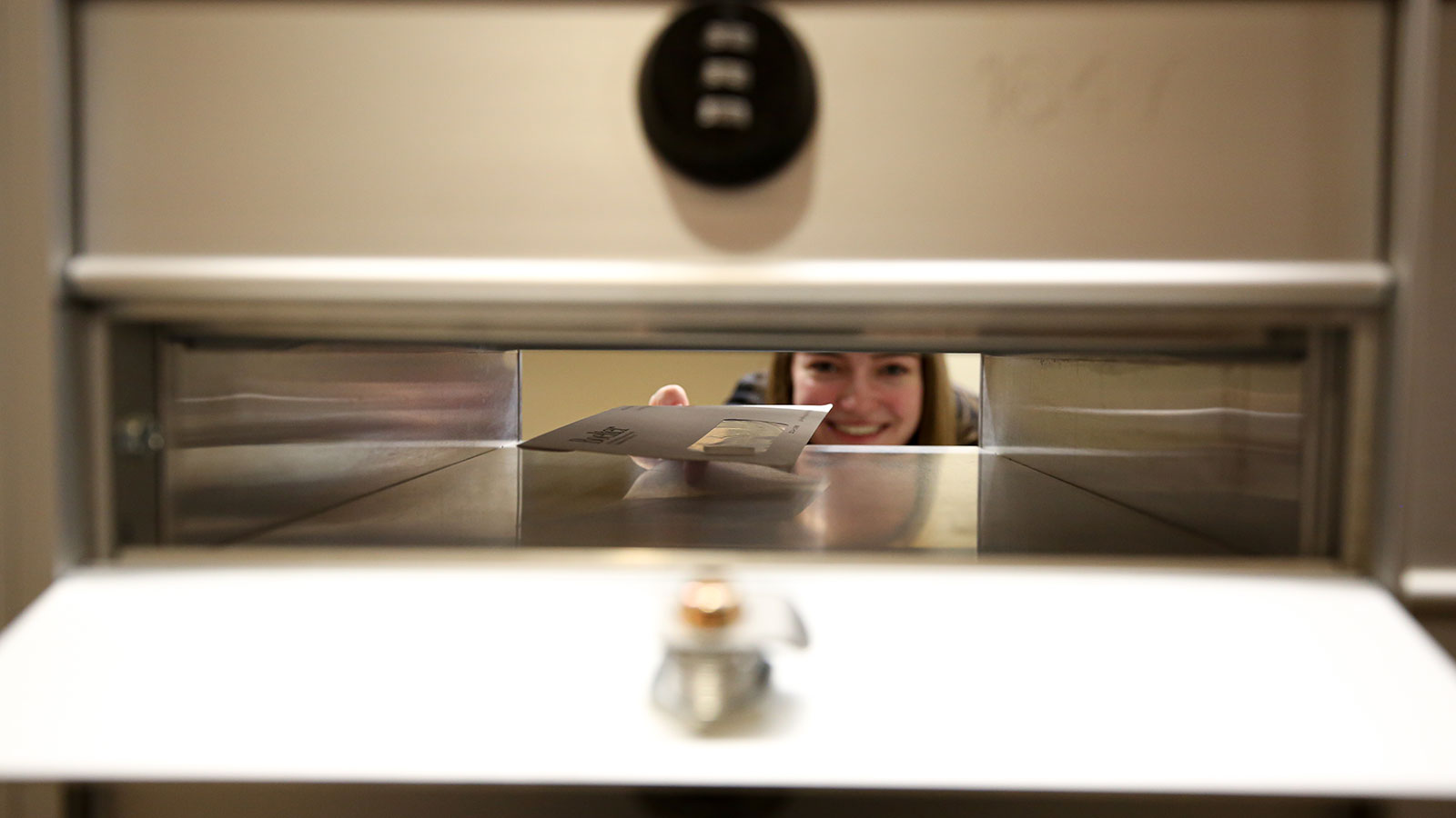 Student filling mailboxes in campus mail center