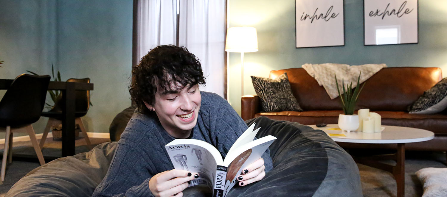 Smiling student relaxing in The Living Room chill space