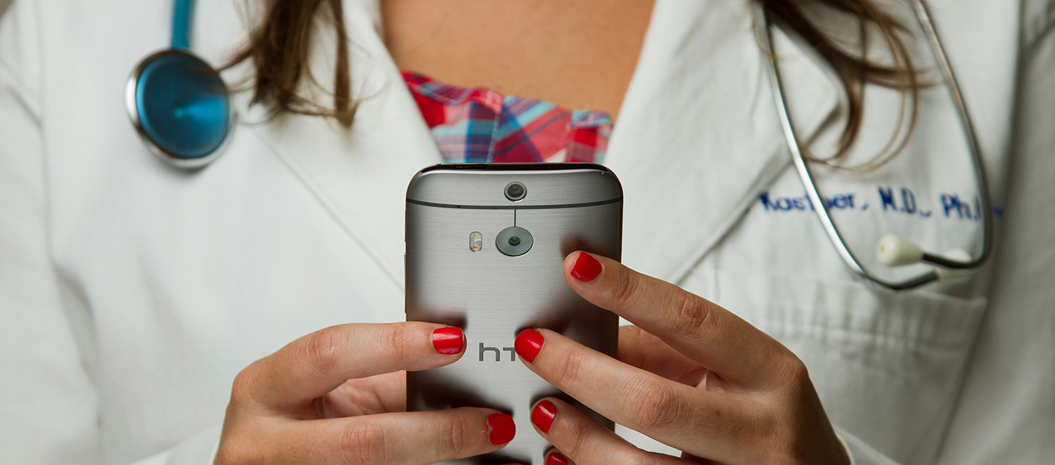 Medical professional checking digital appointments on mobile phone.