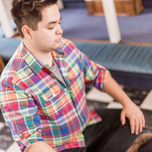 Male student meditating in Allee Chapel.