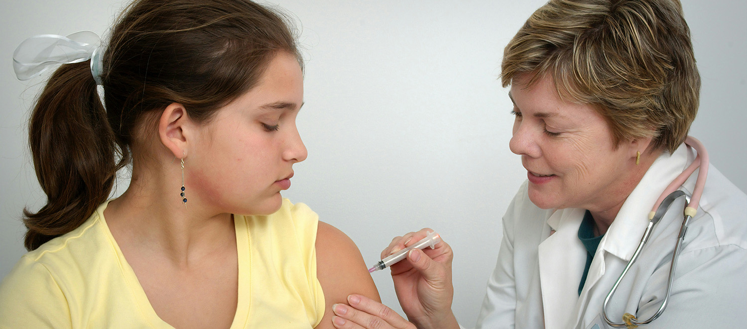 Nurse administering vaccination to a young woman- CDC stock photo