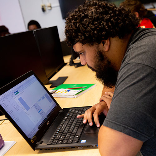 Student works on a business problem on his laptop