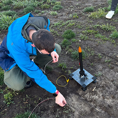 Student in Engineering club preparing a super-sonic rocket for launch.
