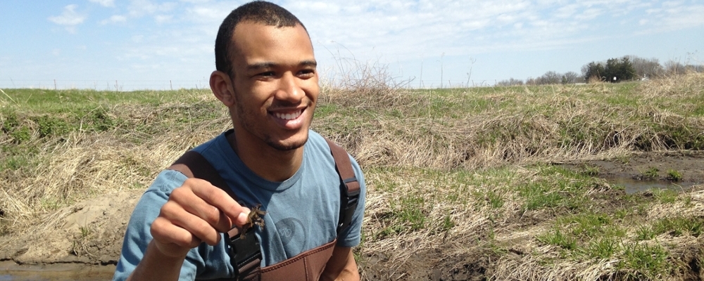 Environmental studies student assessing biodiversity of local stream.
