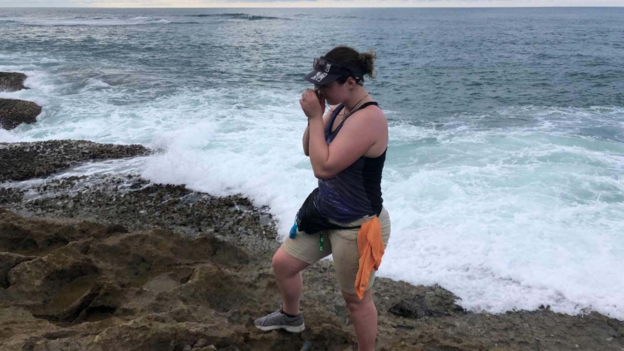 Student collecting samples on a beach