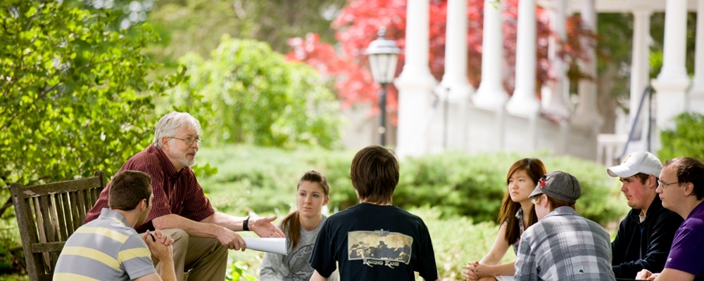 Cornell students sit outside during a class.
