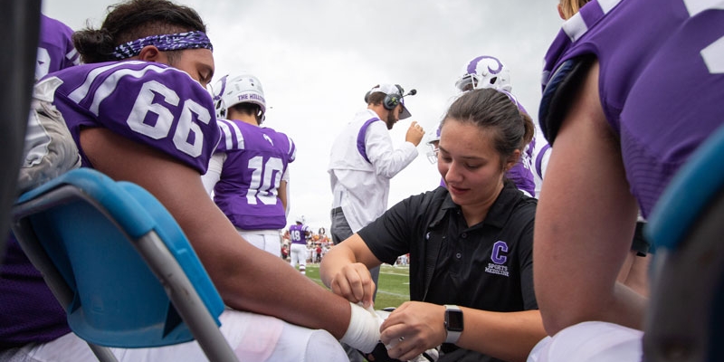 A Cornell College student works as an sports medicine assistant (an internship) for the Cornell Athletics Department. 