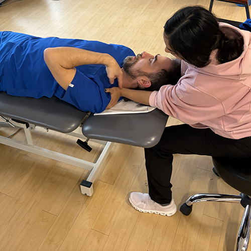 Clinician assessing a patient lying on an exam table