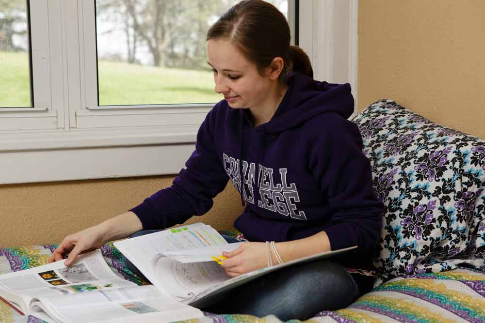 Student studies in her residence hall room.