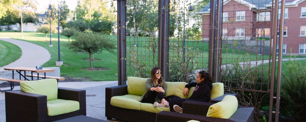 Students sit on an outdoor patio